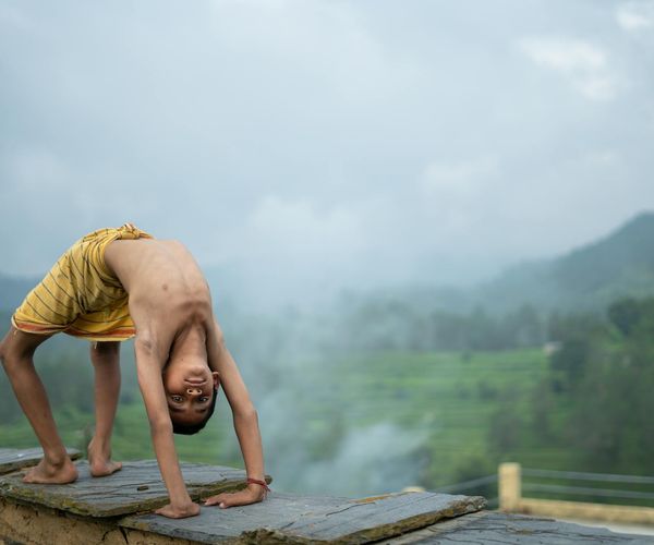 Person meditating outdoors with a serene natural background.