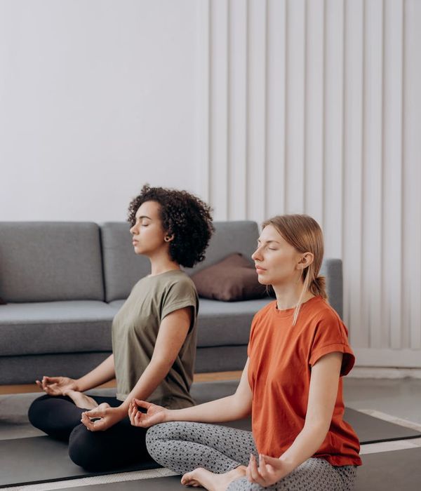 Woman in a peaceful yoga pose in a bright, calm room.